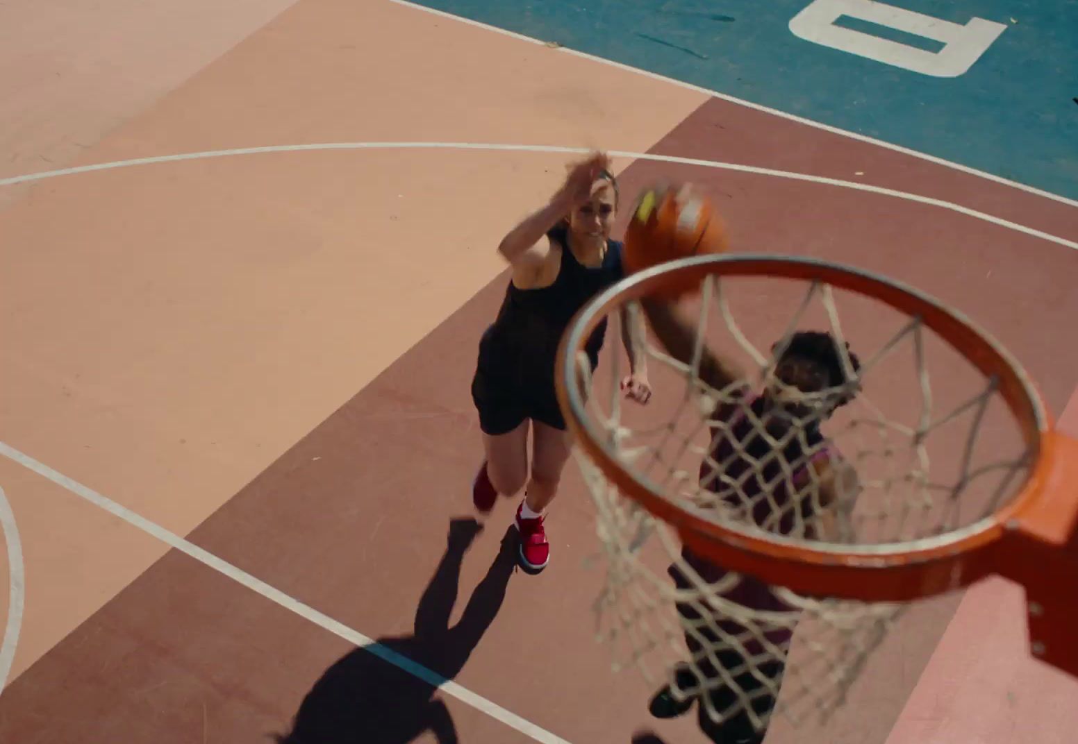 a woman standing on top of a basketball court holding a basketball