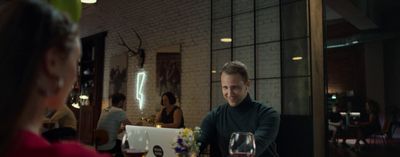 a man sitting at a table with a glass of wine