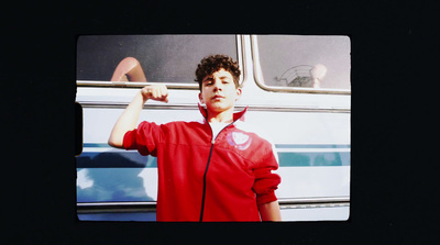 a photo of a young man posing in front of a bus