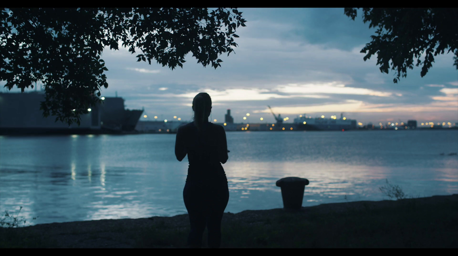 a woman standing next to a body of water