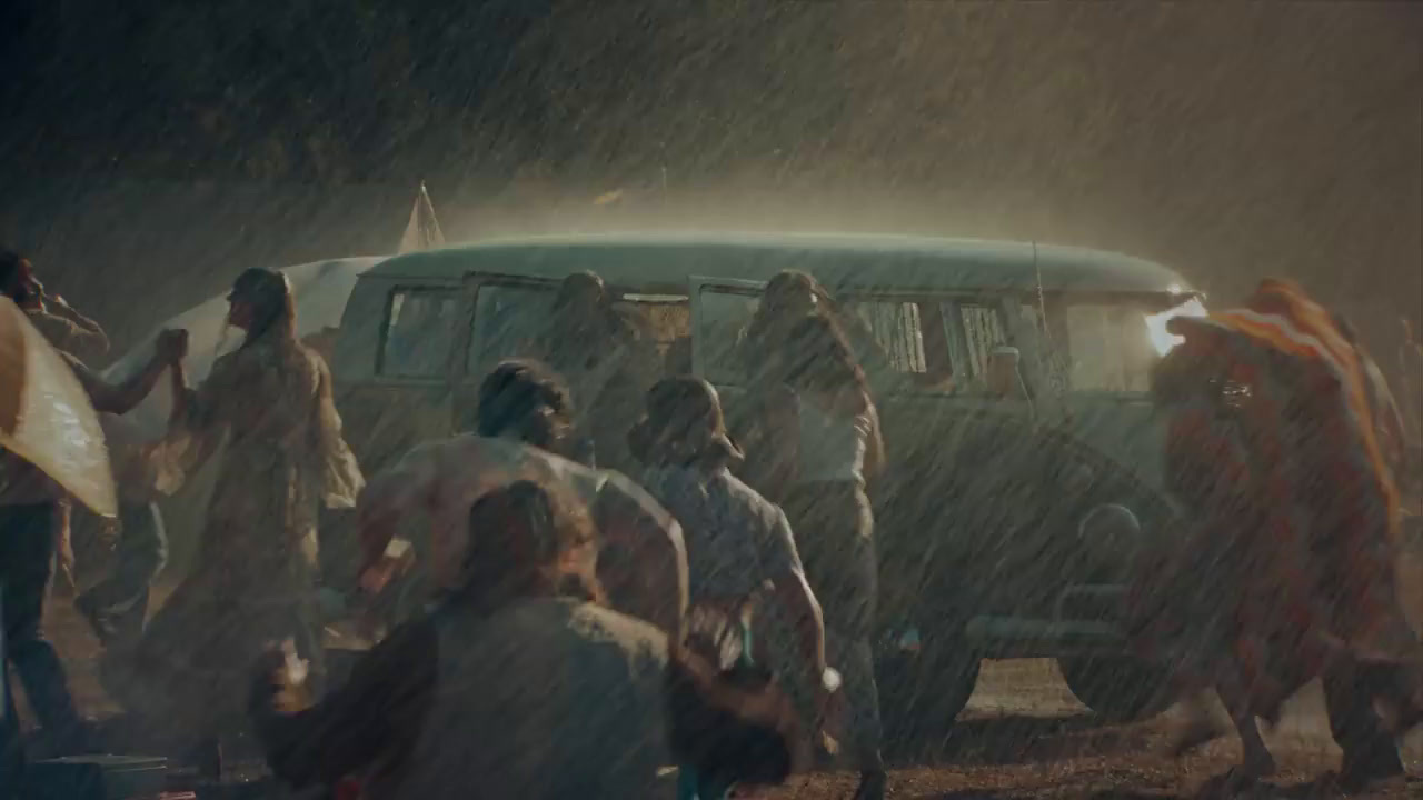 a group of people standing around a van in the rain