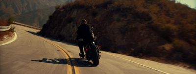 a man riding a motorcycle down a curvy road