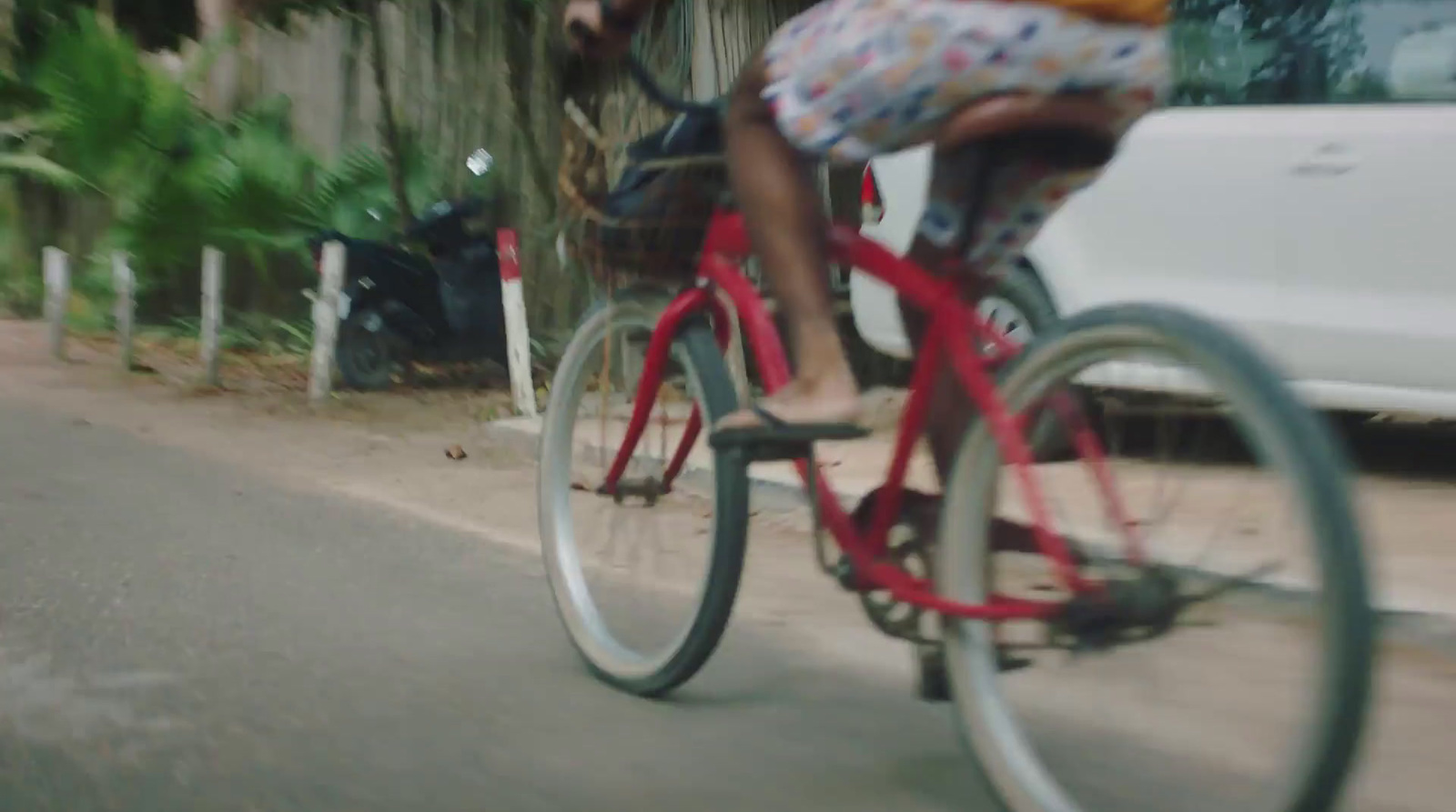 a woman riding a red bike down a street