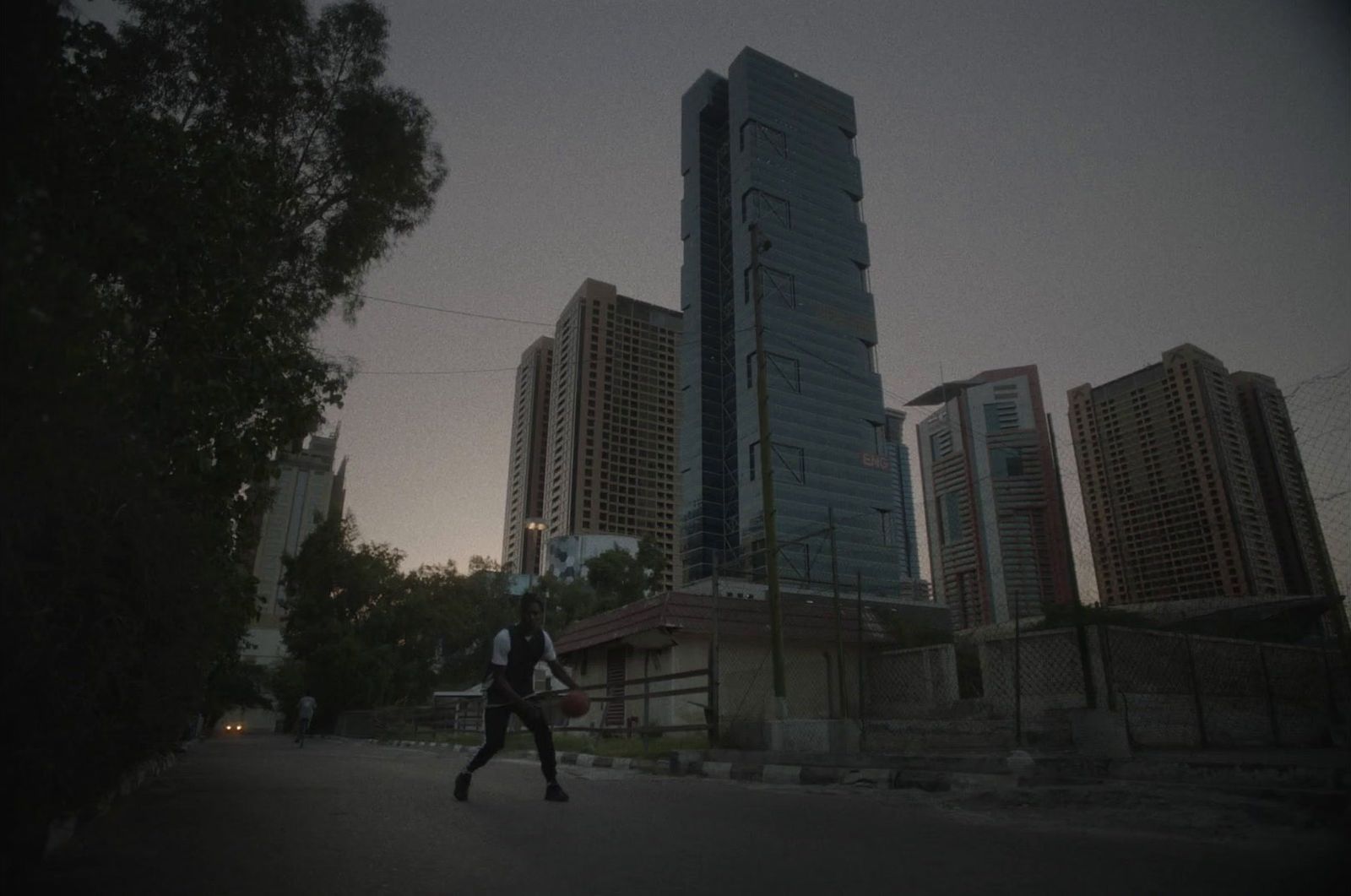 a man walking down a street in front of tall buildings