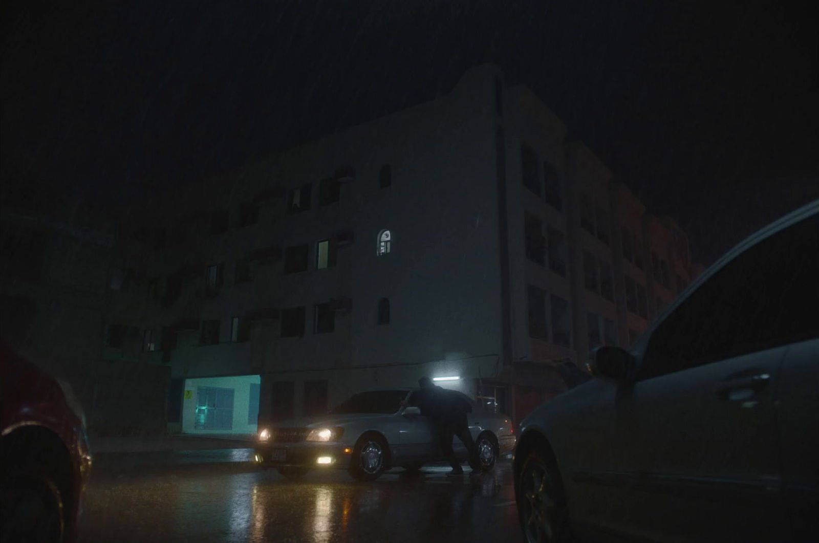 a man standing next to a car in the rain