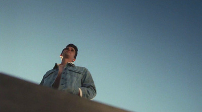 a man talking on a cell phone while standing on a ledge