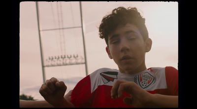 a young man in a red shirt is holding a cell phone