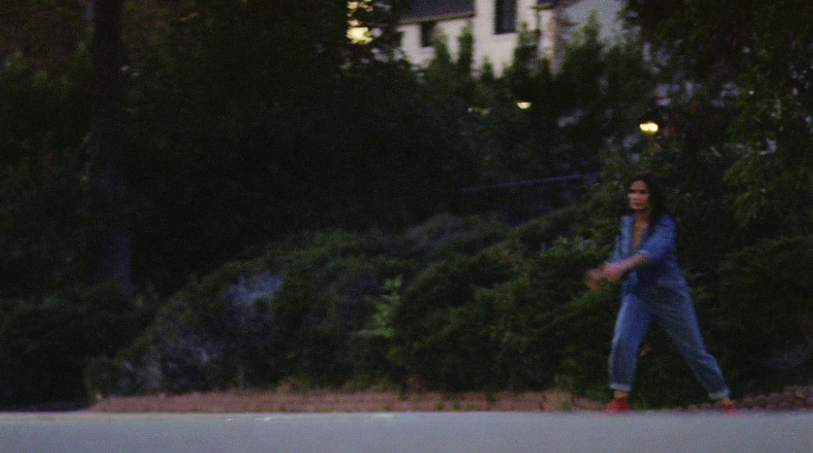 a woman in a blue jacket is throwing a frisbee