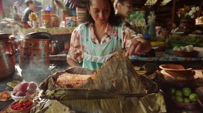 a woman preparing food in a kitchen on a table