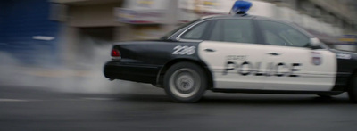 a police car driving down the street with smoke coming out of it