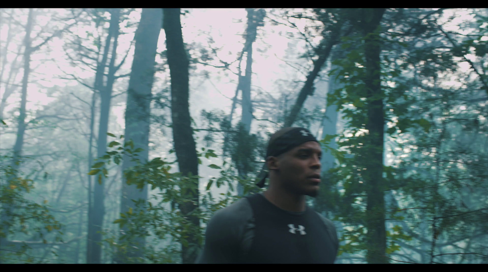 a man in a black shirt standing in a forest