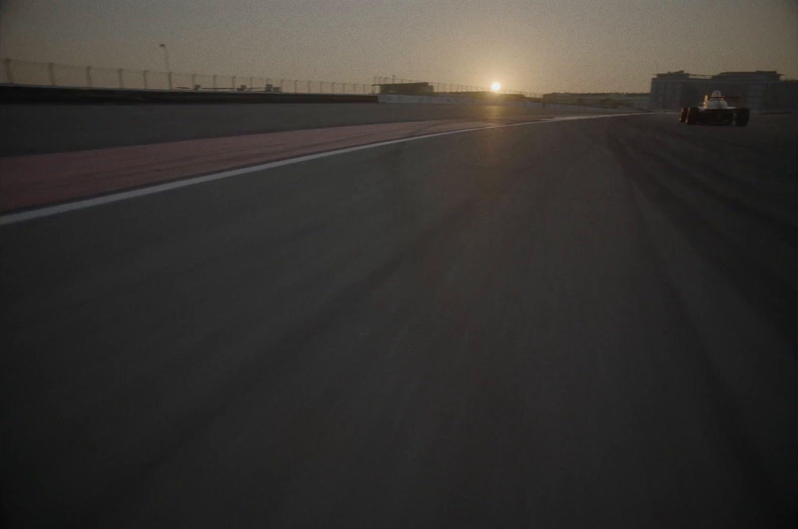 the sun is setting on a race track