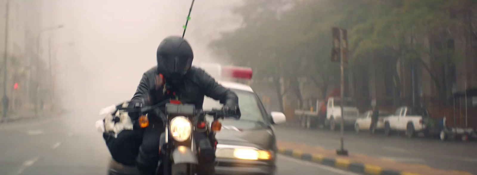 a man riding a motorcycle on a foggy day