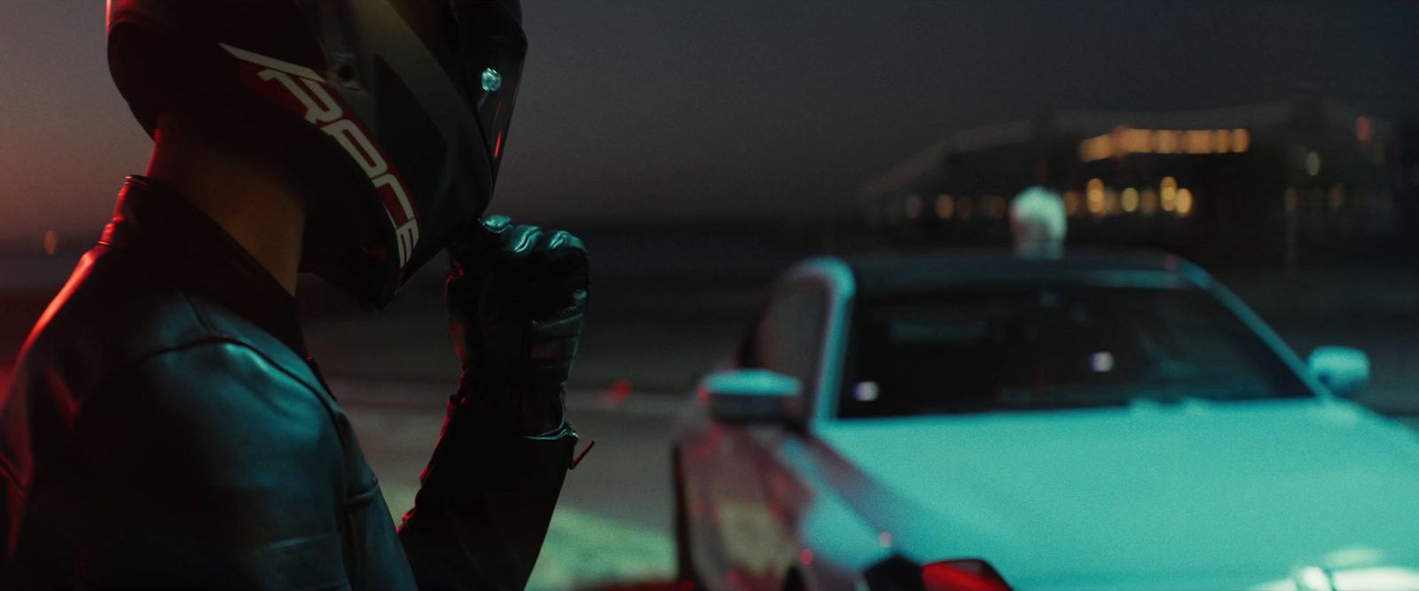 a man in a helmet standing next to a car