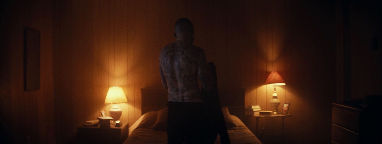 a man standing on a bed in a dimly lit room