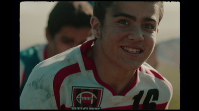 a young man in a soccer uniform is smiling