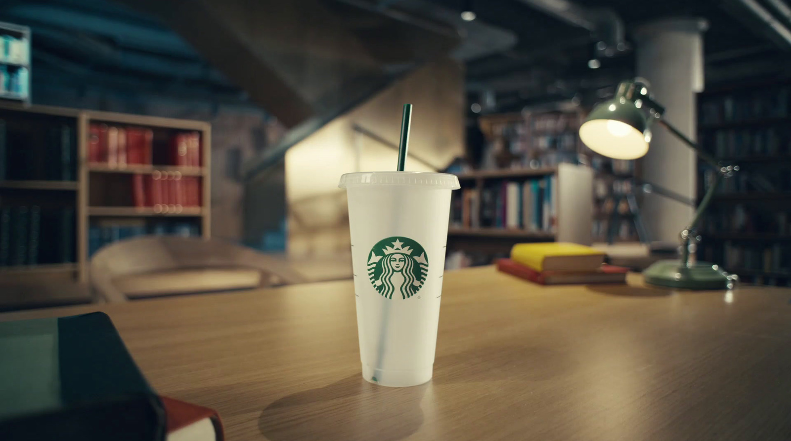 a starbucks cup sits on a table in a library