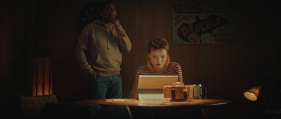 a man and woman sitting at a table in front of a laptop