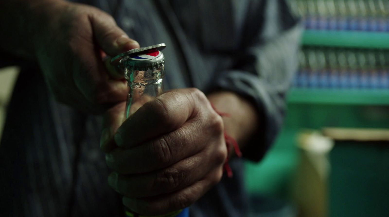 a man holding a glass bottle with a toothbrush in it