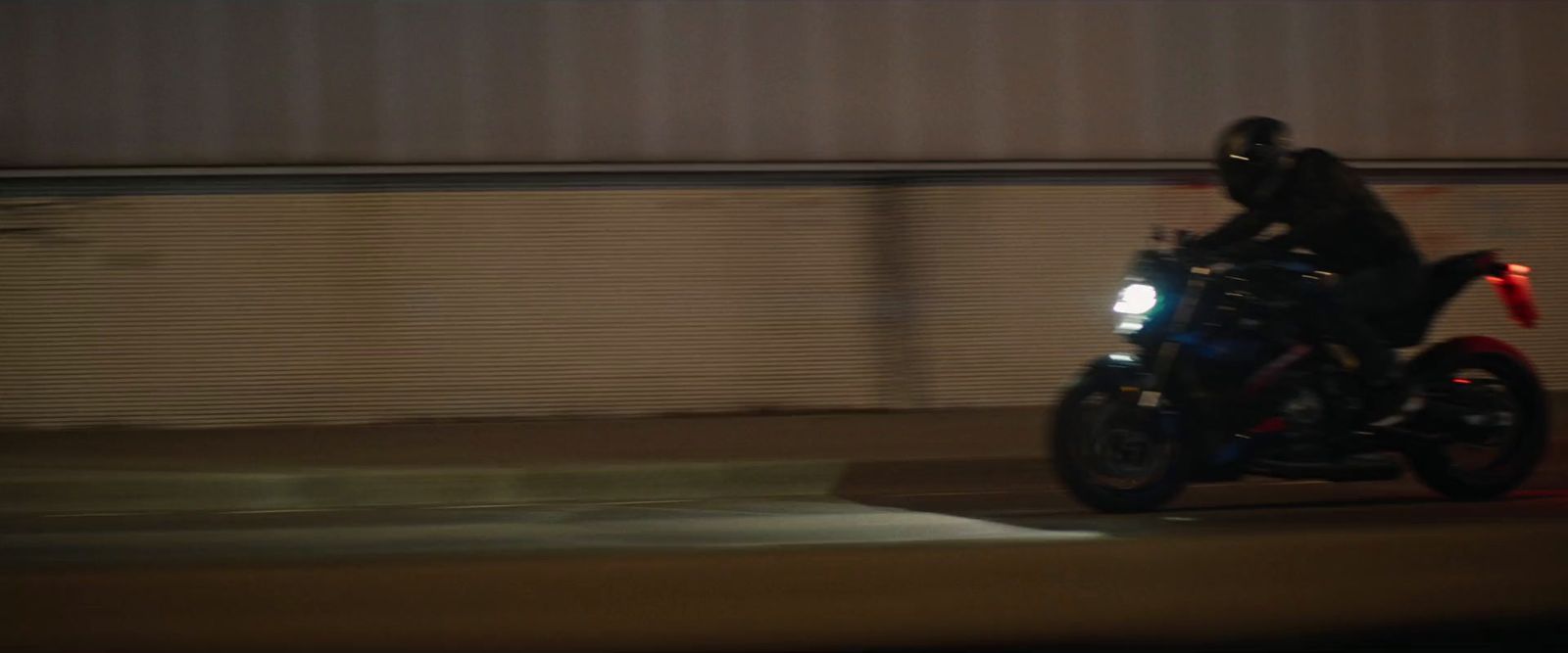 a man riding a motorcycle down a street at night