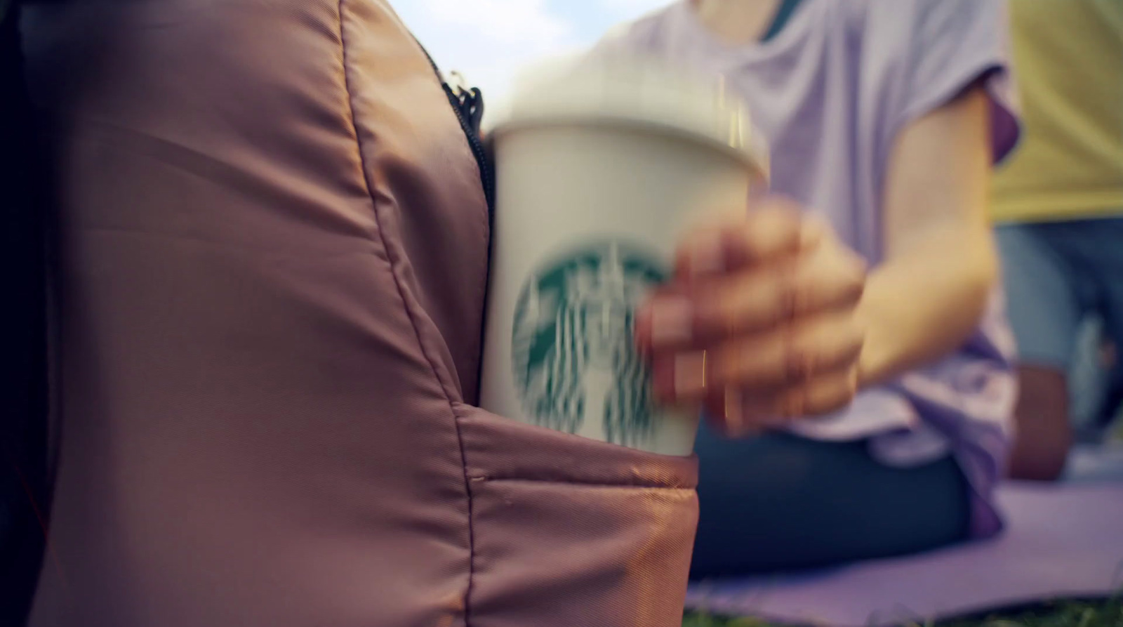 a woman is holding a starbucks cup in her hand