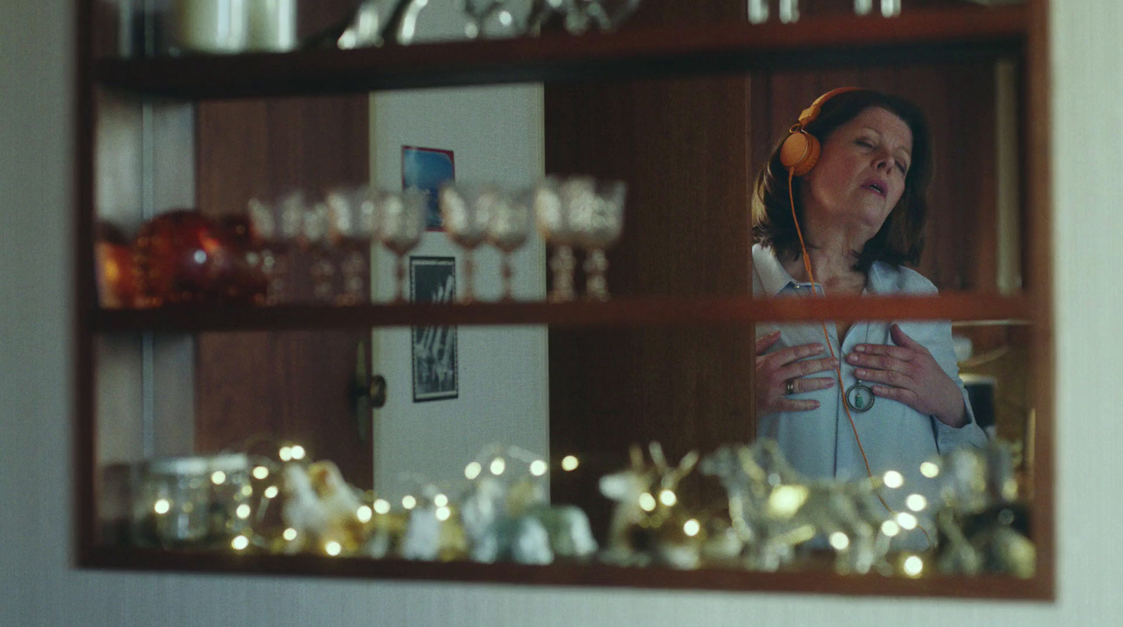 a woman is listening to headphones in front of a mirror