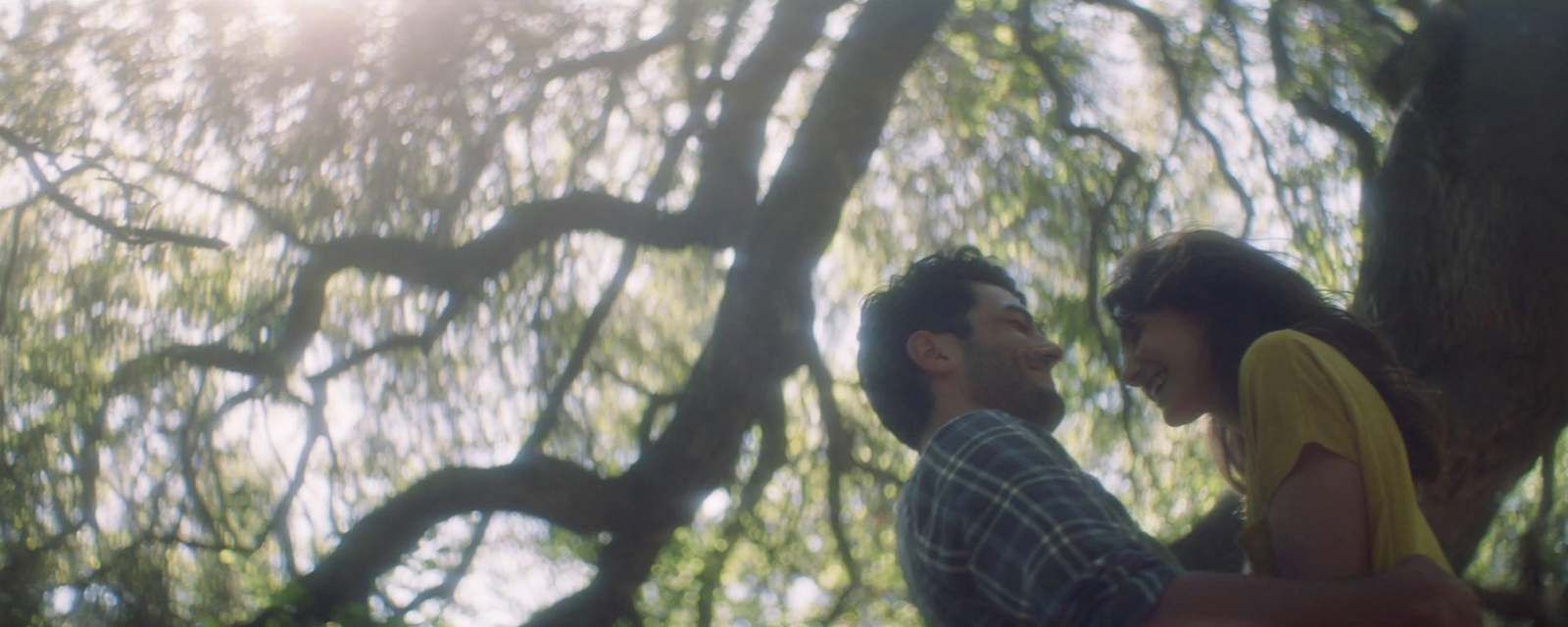 a man and a woman standing in front of a tree