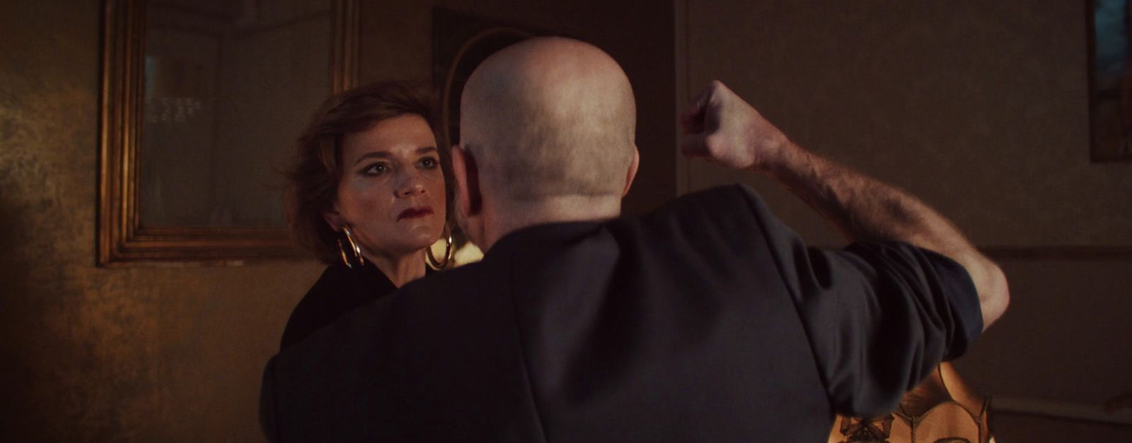 a woman taking a picture of a man in a mirror