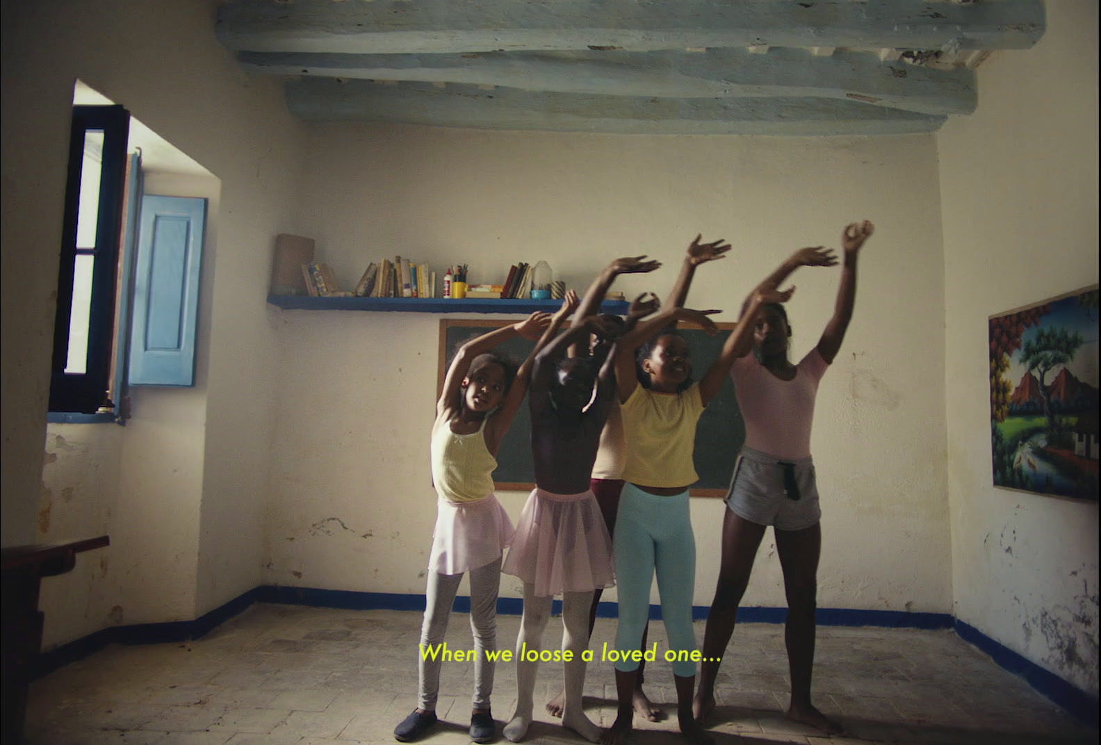 a group of girls in a classroom with their hands raised