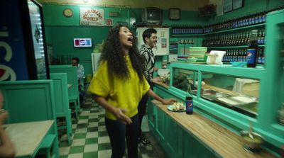 a woman standing in front of a counter in a restaurant