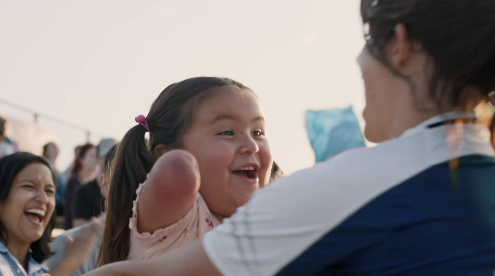 a little girl sitting in the arms of a woman