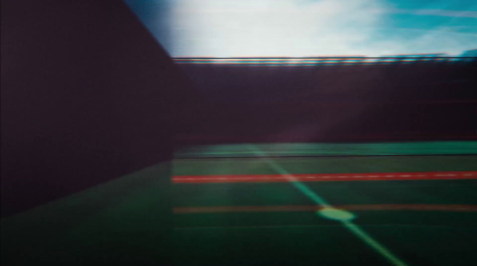 a blurry photo of a tennis court with a sky background