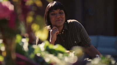 a woman sitting in a flower shop looking at the camera