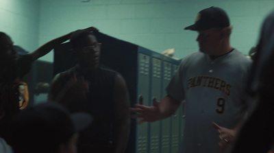 a man in a baseball uniform talking to a group of people