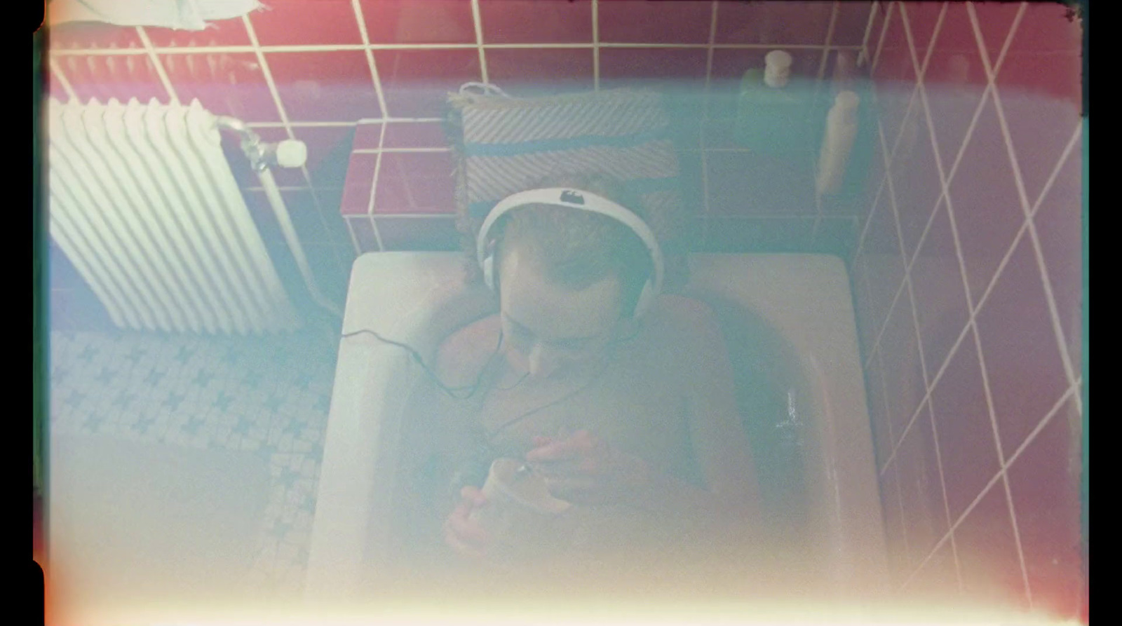 a man sitting in a bathtub with headphones on