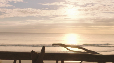 a person laying on a beach next to the ocean