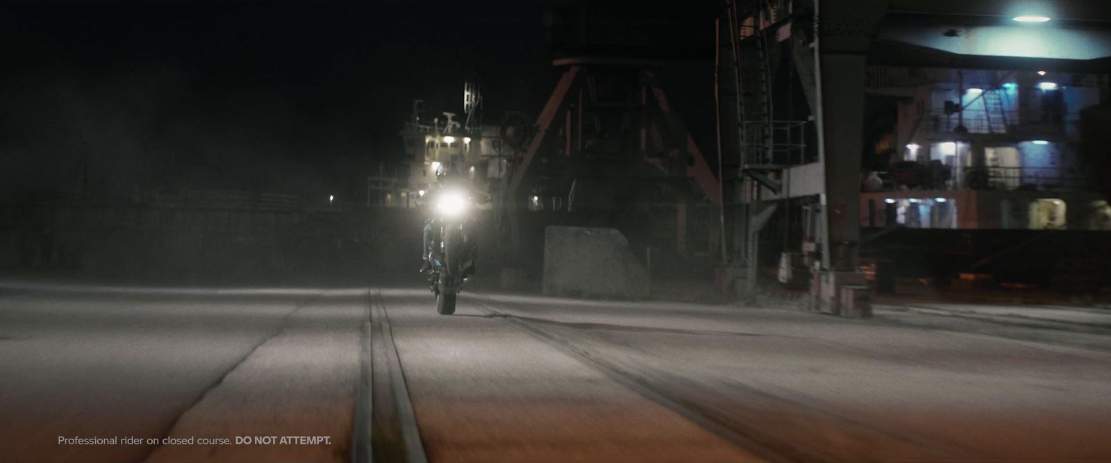 a man riding a motorcycle down a street at night