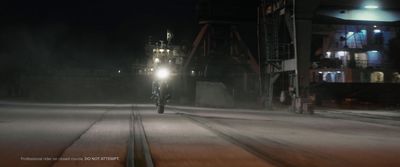 a man riding a motorcycle down a street at night