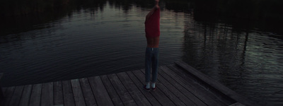 a person standing on a dock holding an umbrella