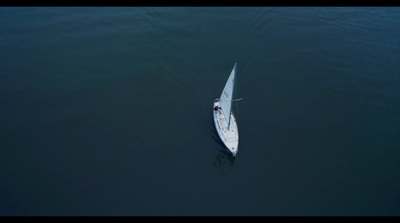 a small white boat floating on top of a body of water