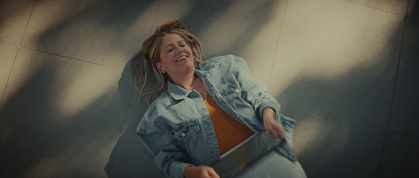 a woman laying on the ground with a laptop