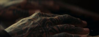 a close up of a person's hands with tattoos