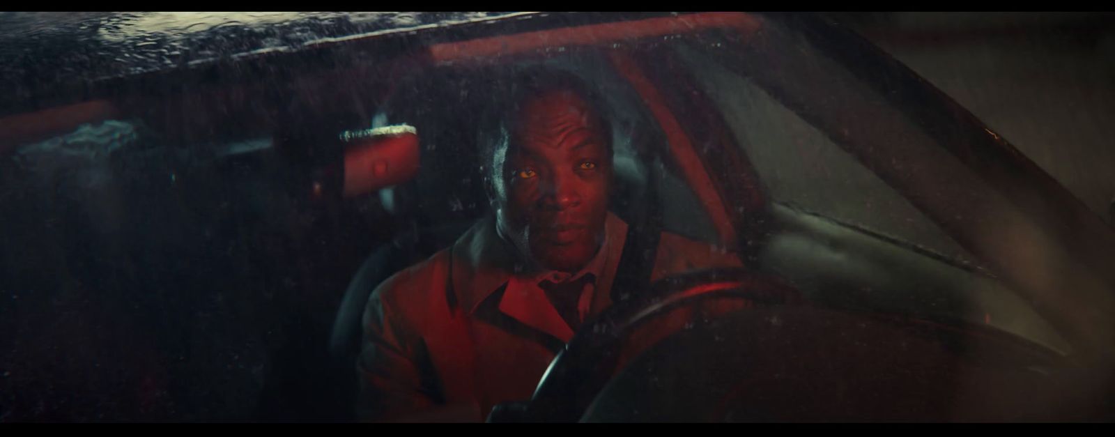 a man driving a car in the rain