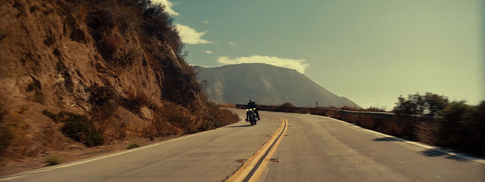 a man riding a motorcycle down a curvy road