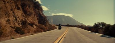 a man riding a motorcycle down a curvy road