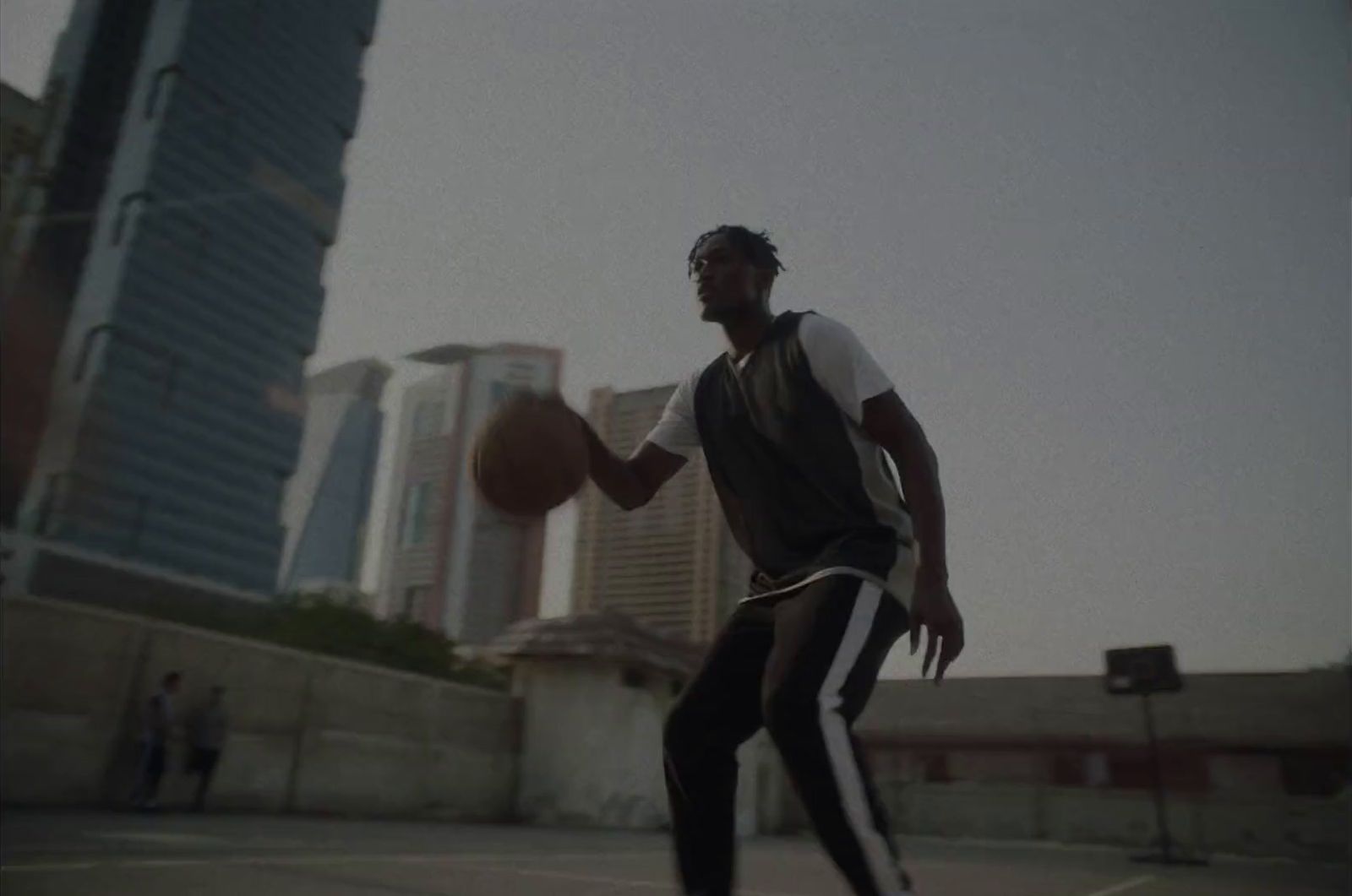 a man holding a basketball on top of a basketball court