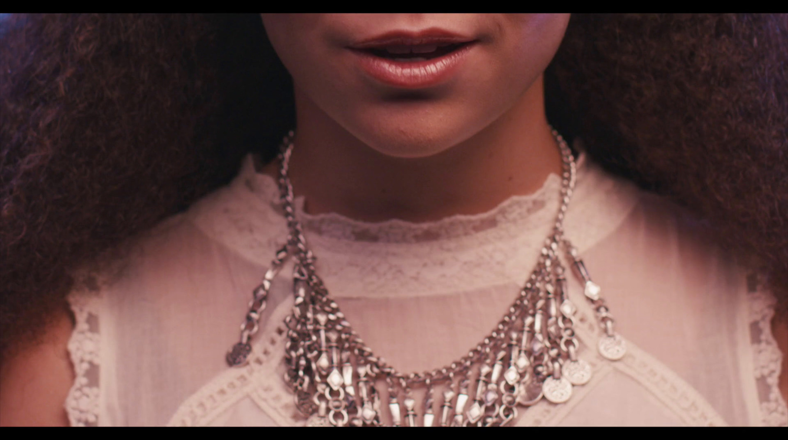 a close up of a person wearing a necklace