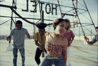 a group of people dancing in front of a hotel sign