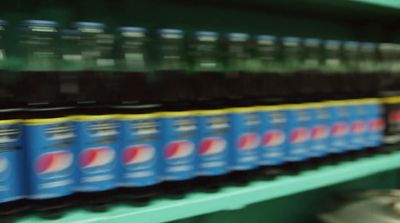 a row of soda cans sitting on top of a shelf