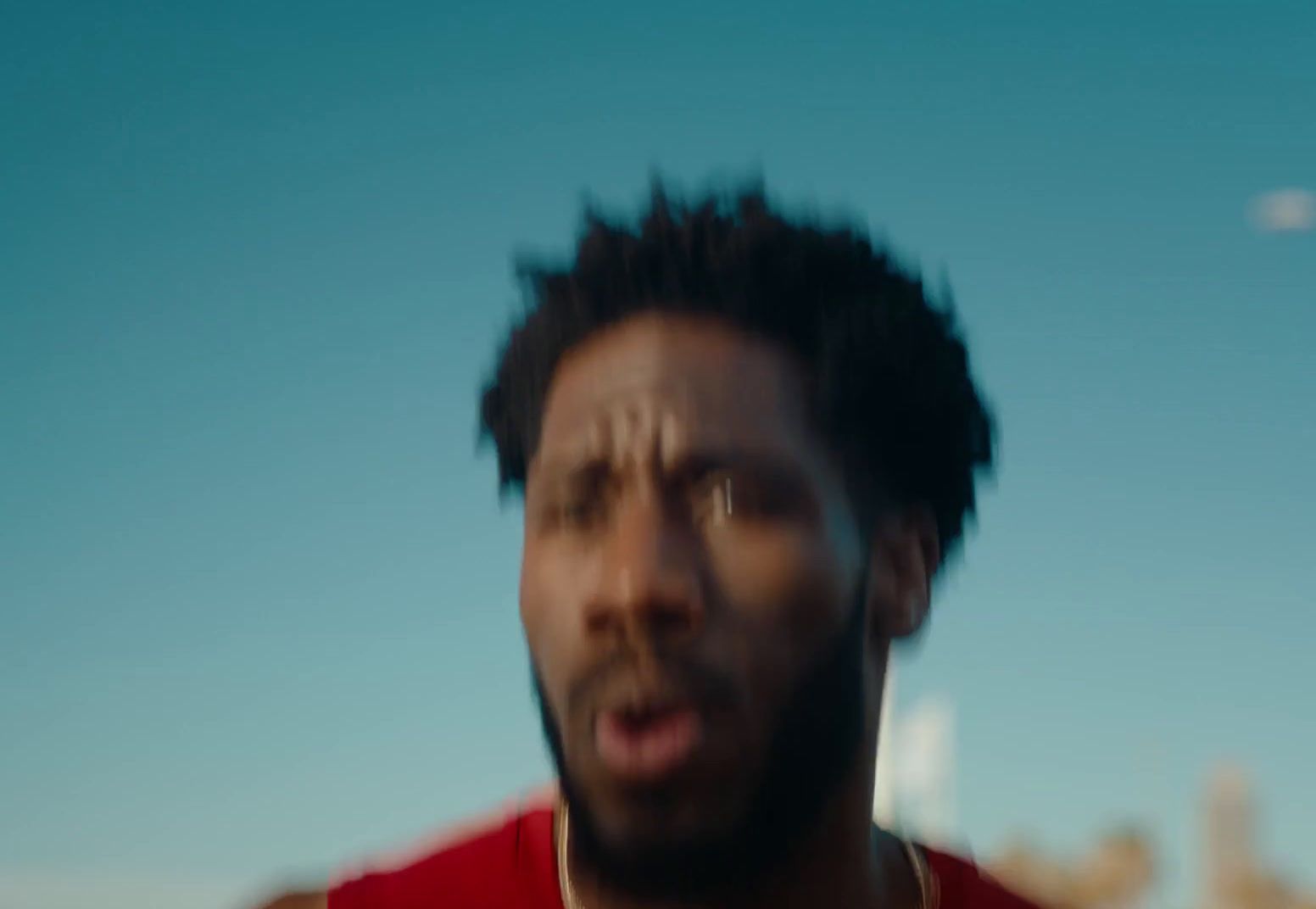 a man with dreadlocks and a red shirt